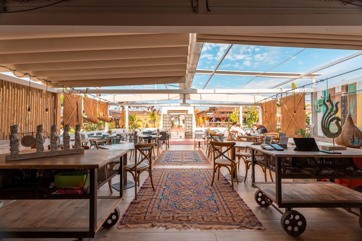 Terraza con mesas largas y alfombra